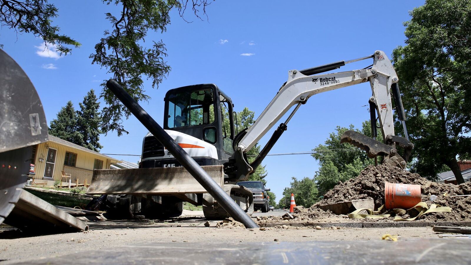 Sewer Experts mini excavator opening a trench on a Denver street