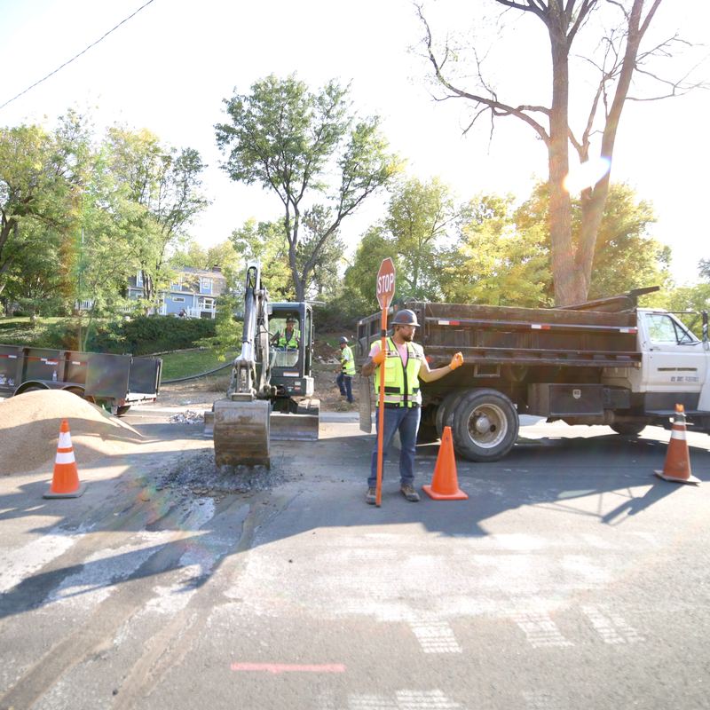 Dump truck and traffic control on a Denver street excavation