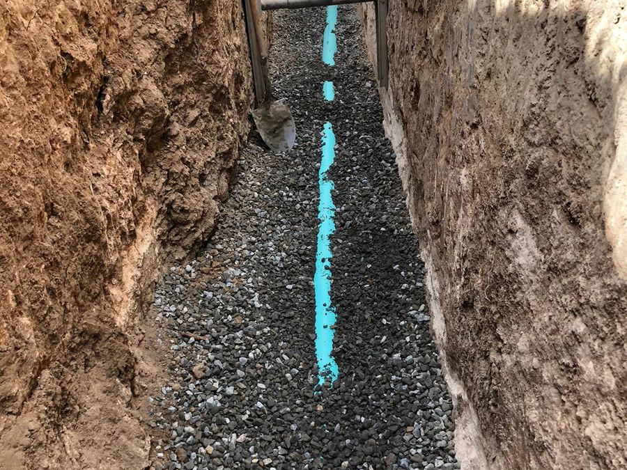 New sewer pipe set on gravel bedding in an open trench