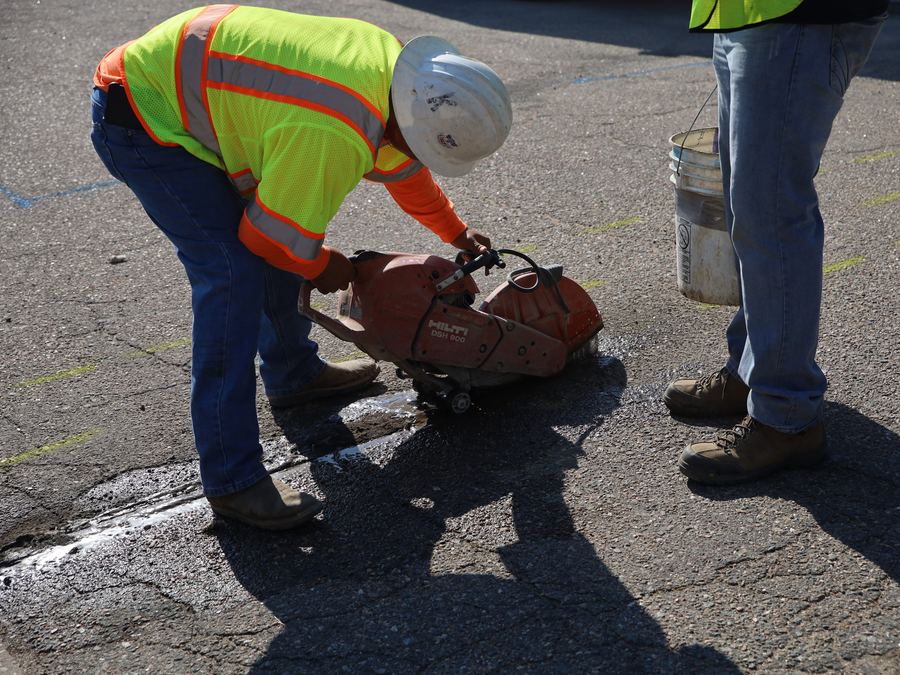 Sewer Experts crew saw-cutting asphalt before a sewer excavation