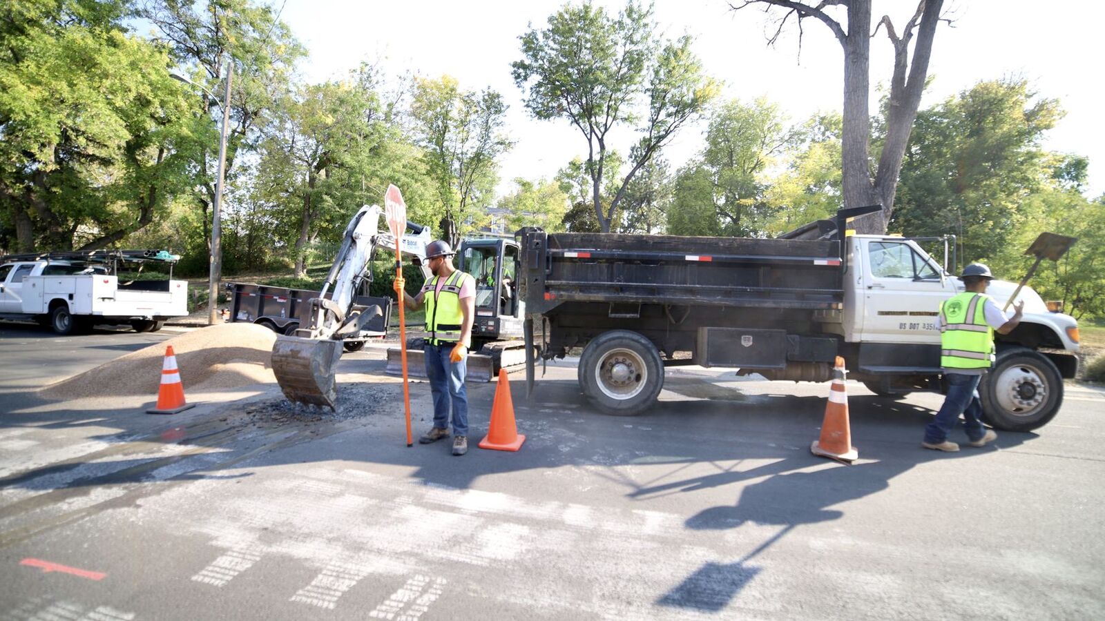 Sewer Experts crew with a dump truck and traffic cones on a Denver street storm drain job