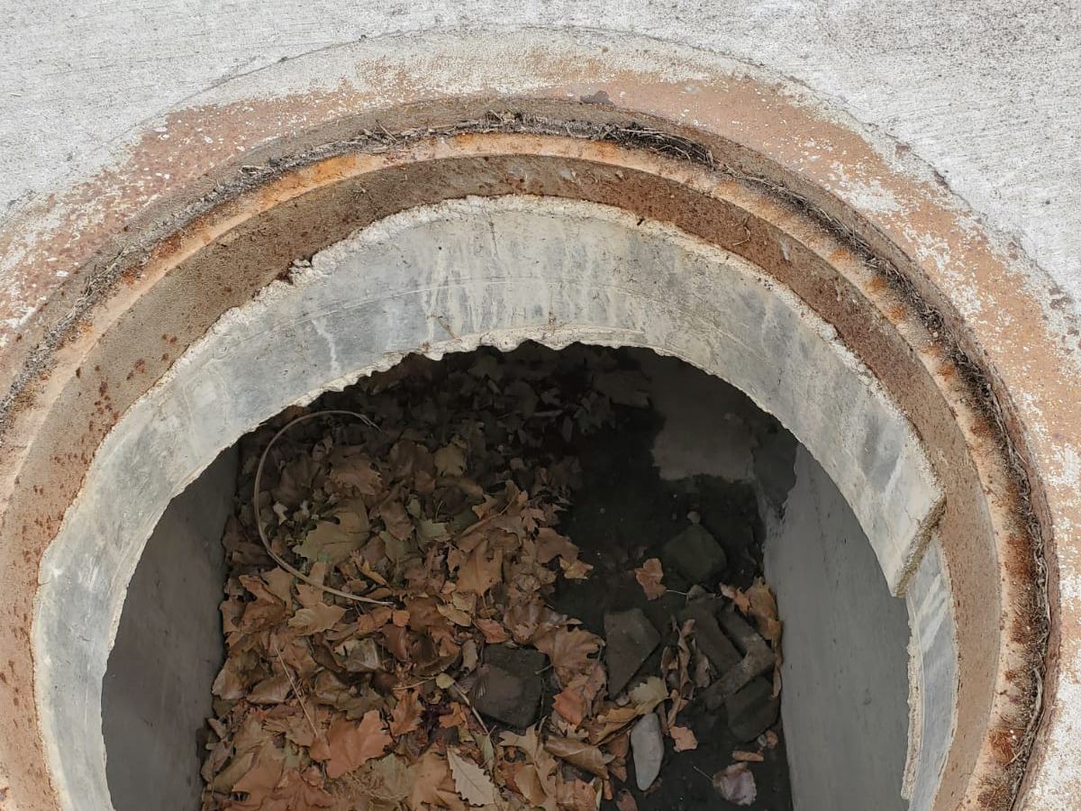 Open manhole showing the concrete barrel and the pipe connection below